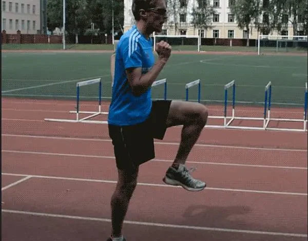 دونده در حال انجام حرکت زانوبلند روی پیست دوومیدانی