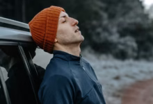 مردی کهبه ماشین تکیه داده است