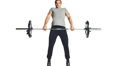 ورزشکار آقا در حال بلندکردن هالت برای حرکت پاور کلین