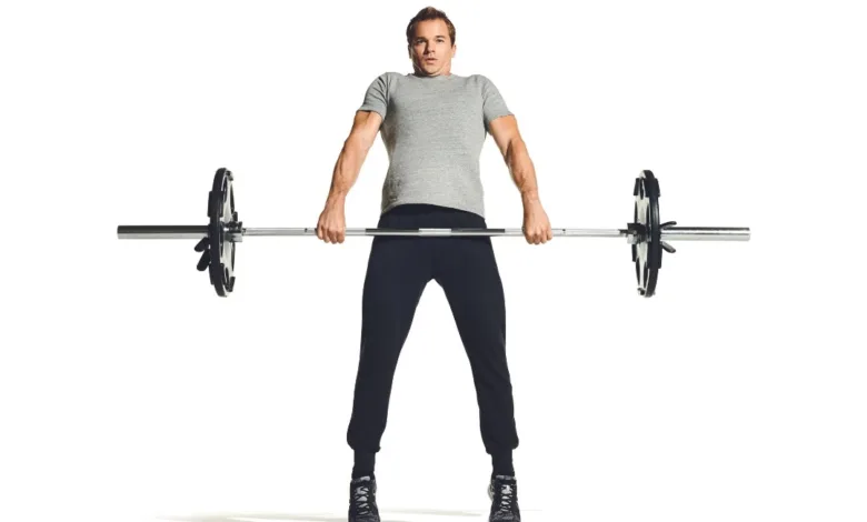 ورزشکار آقا در حال بلندکردن هالت برای حرکت پاور کلین